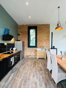 eine Küche mit einem Holztisch und eine Küche mit einem Kühlschrank in der Unterkunft Chateau Humieres Coach House in Humières