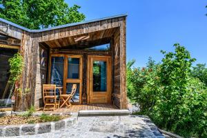 a tiny house with a wooden door and a patio at der baum hideaway in Inzersdorf im Kremstal