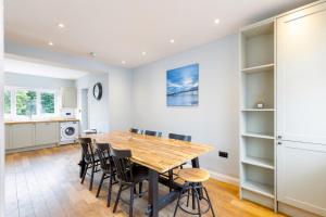 a kitchen and dining room with a wooden table and chairs at 3Bed house with games room, hot tub & free parking in Brighton & Hove