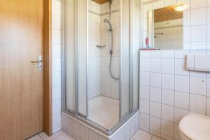 a shower with a glass door in a bathroom at Haus Unterseeblick - Sonnenaufgang in Gaienhofen +15 photos