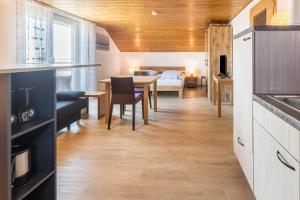 eine Küche und ein Esszimmer mit einem Tisch und einem Schlafzimmer in der Unterkunft Haus Unterseeblick - Sonnenaufgang in Gaienhofen