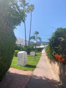 een stoep met een stenen brievenbus naast een straat bij Casa adosada Huerta del Prado in Marbella