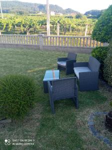 eine Terrasse mit zwei Stühlen und einem Tisch im Gras in der Unterkunft Casa Sartages in Ribadumia