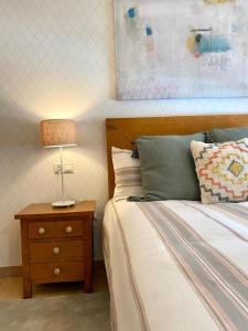 Dormitorio con cama y mesita de noche con lámpara en Andainas Apartamentos Turísticos B en Milladoiro