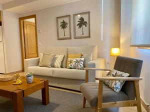 sala de estar con sofá y silla en Andainas Apartamentos Turísticos B en Milladoiro