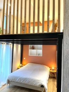 - une chambre avec un lit doté d'une tête de lit en bois dans l'établissement Le petit nid d'Aline, à Arras
