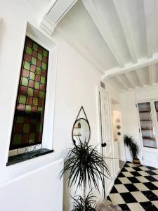un couloir avec un vitrail et une plante dans l'établissement Le petit nid d'Aline, à Arras