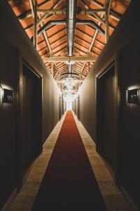 einen langen Korridor mit rotem Teppich in einem Gebäude in der Unterkunft LANDHOTEL ALTE ZOLLSTATION- Historical Building in Pittenhart