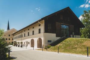 un vecchio edificio con un tetto nero su una strada di LANDHOTEL ALTE ZOLLSTATION- Historical Building a Pittenhart