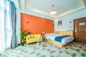 um quarto de hotel com uma cama e uma cadeira amarela em Yixun Inn em Zhangjiajie