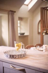 einen Tisch mit einer Glasschüssel mit einer Tasse Zitronen in der Unterkunft Eastside Byre - Family cottage in the Pentland Hills near Edinburgh in Penicuik