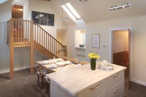 a kitchen and dining room with a table and chairs at Eastside Byre - Family cottage in the Pentland Hills near Edinburgh in Penicuik