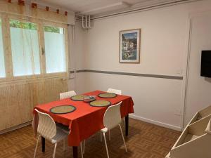 a dining room with a red table and chairs at La Croix Blanche in Beaurepaire-en-Bresse