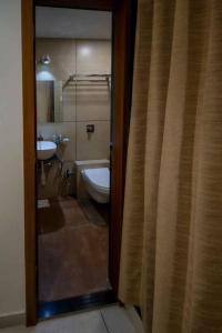 a bathroom with a toilet and a sink at HOTEL VENUS in Veraval