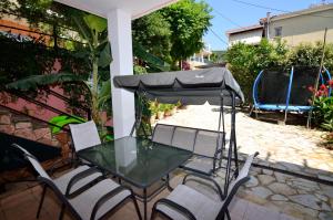 a table and chairs with an umbrella on a patio at Villa Ektoras by EY Villas in Parga
