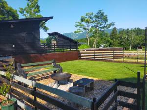 a backyard with a grill and a fence at HIEDA SANSO in Otari