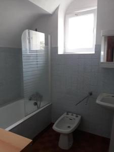 La salle de bains blanche est pourvue de toilettes et d'un lavabo. dans l'établissement Kerleuquer Ty Nevez, à Plobannalec-Lesconil