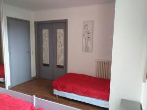 - une chambre avec un lit rouge et un miroir dans l'établissement Kerleuquer Ty Nevez, à Plobannalec-Lesconil