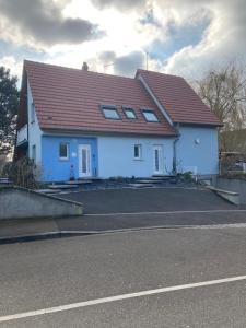 una casa blanca con techo rojo en una calle en B&B jaune, Appartement indépendant, parking, wifi près de Strasbourg, en Ittenheim
