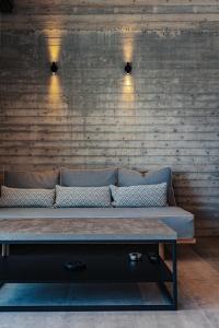 a couch in a room with a brick wall at olive blue thassos luxury villas in Astris