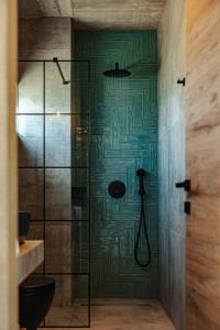 bagno con doccia e porta in vetro di olive blue thassos luxury villas ad Astrís