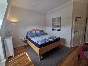 a bedroom with a bed with blue pillows at Haus Deichvoigt in Cuxhaven