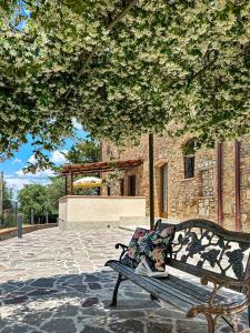 a park bench with a pillow sitting under a tree at TORREVISTA - Opened 2022 in Montaione