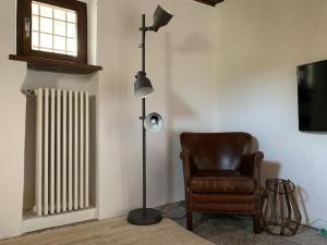 a room with a lamp and a chair and a floor lamp at Rustico Lucy in Gordola