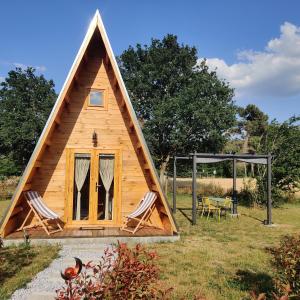 ein winziges Haus mit zwei Stühlen und einem Pavillon in der Unterkunft Tipi Apache des monteaux in Vivy