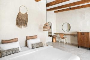 a bedroom with a white bed and a mirror at Hotel Anilevich Mansion in Beer Sheva