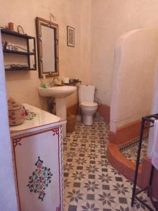 a bathroom with a sink and a toilet and a mirror at Logement entier riad Dar Sana in Marrakesh