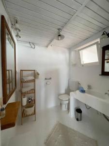 a white bathroom with a toilet and a sink at Sunrise SeaView Apartment Fiesa in Piran