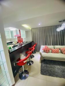 a living room with a couch and red stools at Crown Regency Ultima Residences in Cebu City