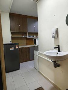a kitchen with a sink and a refrigerator at De Cameron Guest House in Tanah Rata