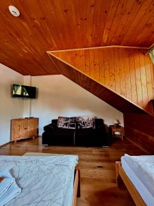 a bedroom with a bed and a wooden ceiling at Penzión Driečna in Havaj