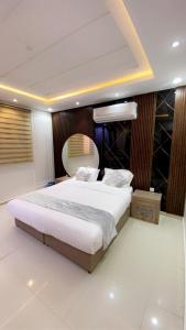a bedroom with a large white bed and a mirror at Layali Rahaf Chalets in Abha