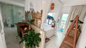 a bathroom with a bath tub and a toilet at Sollaris Ecopousada in Japaratinga