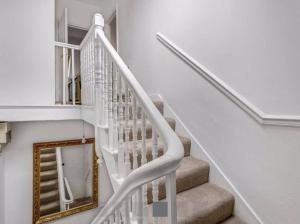 a white stairway with a mirror and a mirror at Homely 1 BR apartment with parking in Streatham in London