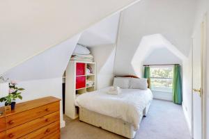 a white bedroom with a bed and a window at Homely 1 BR apartment with parking in Streatham in London