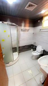 a bathroom with a shower and a toilet and a sink at Layali Rahaf Chalets in Abha