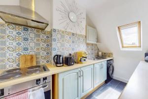 a small kitchen with a sink and a stove at Homely 1 BR apartment with parking in Streatham in London
