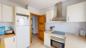 a kitchen with white cabinets and a white refrigerator at Casa Quisqueya - A Murcia Holiday Rentals Property in Roldán