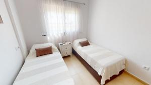 ein Schlafzimmer mit zwei Betten und einem Fenster in der Unterkunft Casa Quisqueya - A Murcia Holiday Rentals Property in Roldán + 18 Fotos