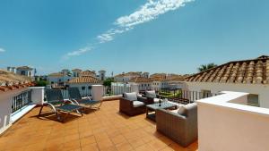 eine Terrasse mit Stühlen und Tischen auf einem Dach in der Unterkunft Casa Quisqueya - A Murcia Holiday Rentals Property in Roldán