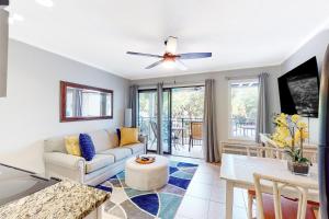 ein Wohnzimmer mit einem Sofa und einem Deckenventilator in der Unterkunft Sea Side Villas 108 in Hilton Head Island