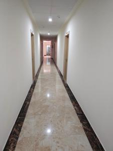 an empty corridor with white walls and a marble floor at Pink Vista Hotel in Jaipur