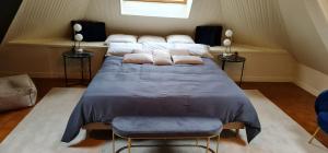 Un dormitorio con una cama grande con almohadas. en Manoir de la Sauldre, en Argent-sur-Sauldre