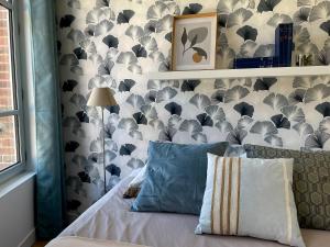 a bedroom with a bed with a wall covered in umbrellas at Appartement cosy et lumineux centre-ville #4 in Dreux