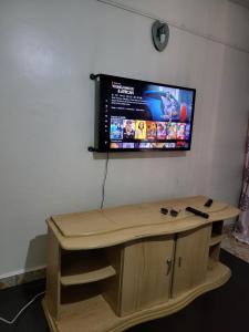 a tv on a wall above a wooden desk at G&G Homes Ngala 1 Bedroom in Nakuru