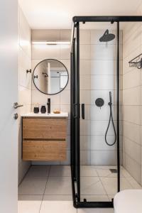 a bathroom with a shower with a sink and a mirror at Mate GEORGE - By HOMY in Tel Aviv